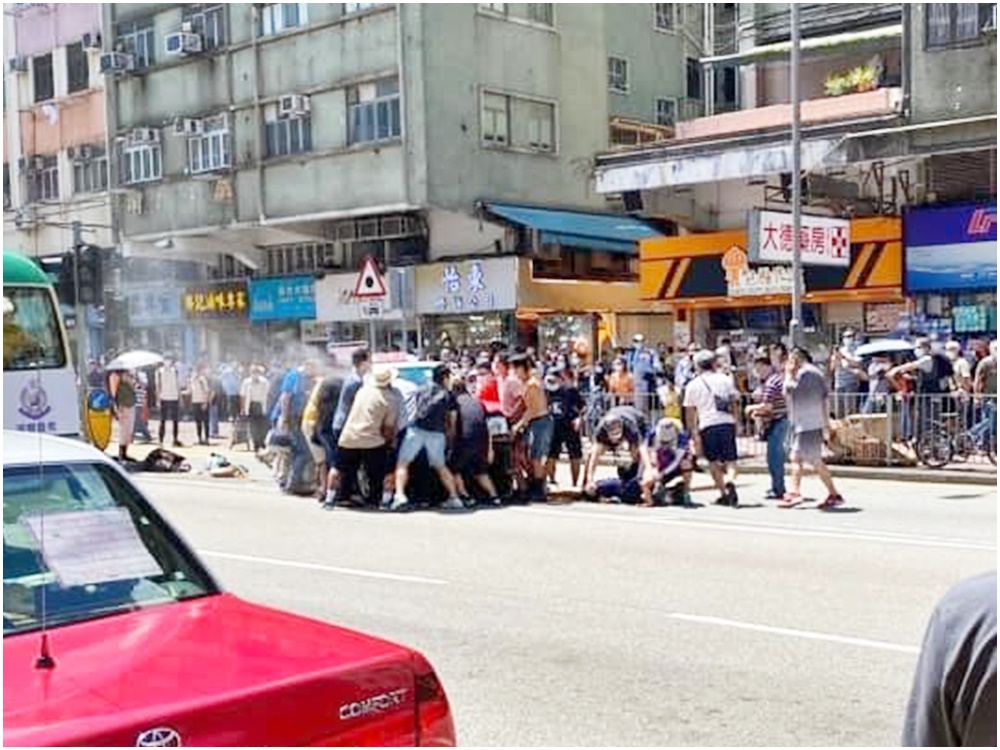 意外中有人疑被捲入車底,由大批熱心街坊合力抬起的士救出。區議員黃兆健圖片