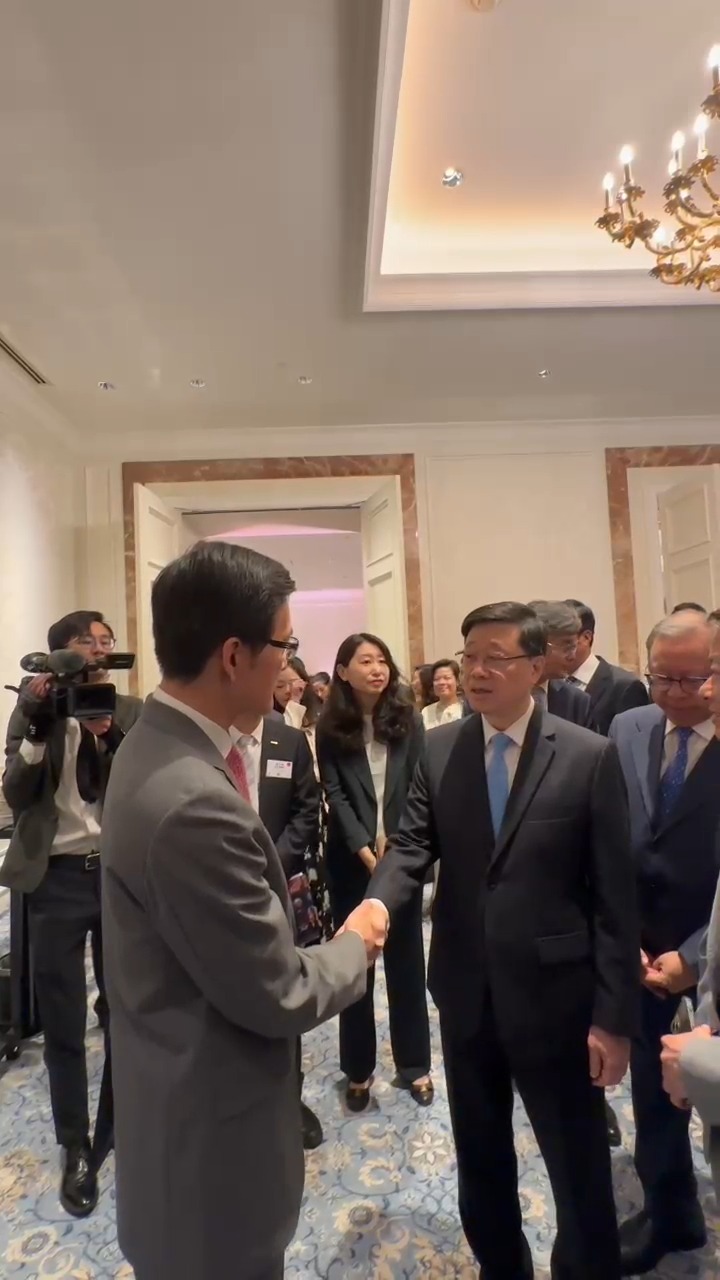 李家超與微眾銀行副行長陳峭握手。 李家超與微眾銀行副行長陳峭握手。