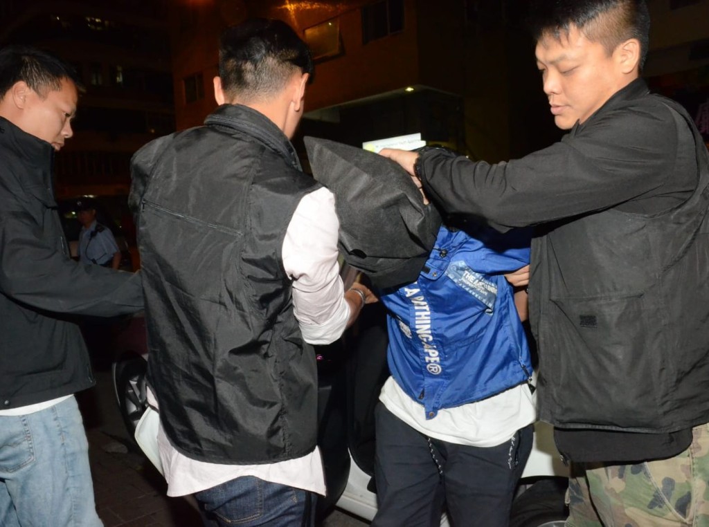 開槍男子被戴上手銬,其後西九龍總區將他押回寓所搜證。