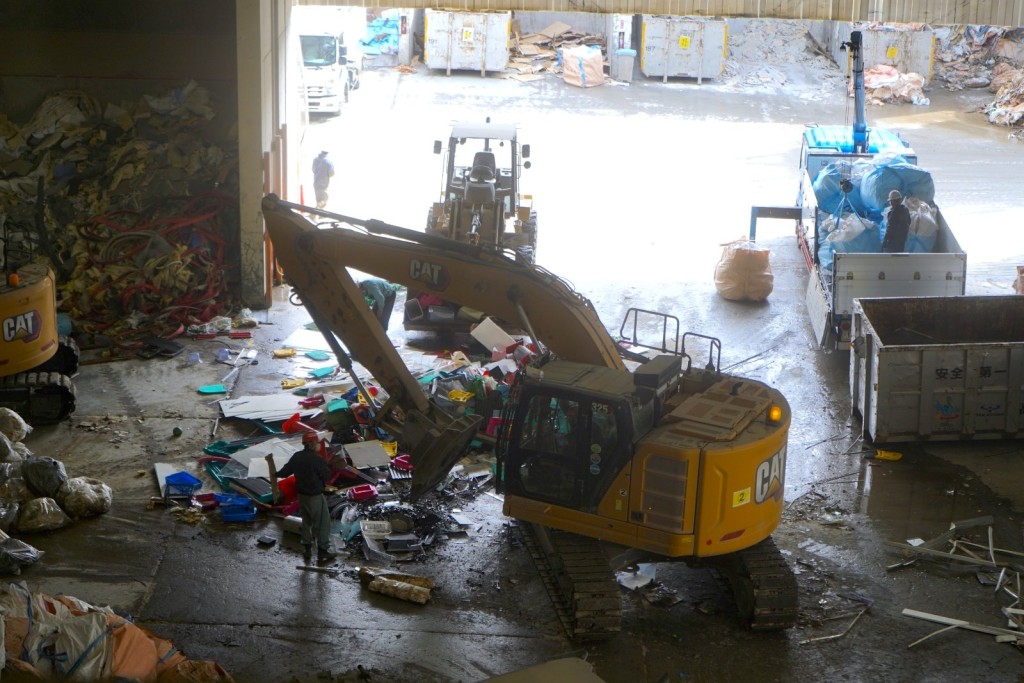 记者踏足回收工业废料的「高峻兴业」，只见多辆工程车把废料分门别类，部分再由人手挑选。