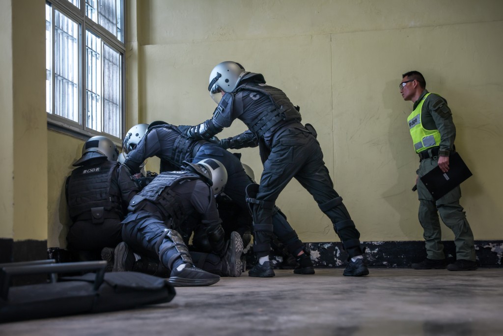 學員於真實懲教院所環境中，進行防暴制亂的模擬訓練。