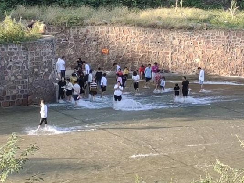 大批遊客不顧安全警示涉水遊玩。網圖