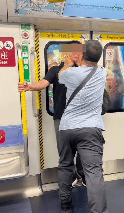斜孭袋男突發難伸手「叉頸」,將背囊男硬推至車門位置。 斜孭袋男突發難伸手「叉頸」,將背囊男硬推至車門位置。