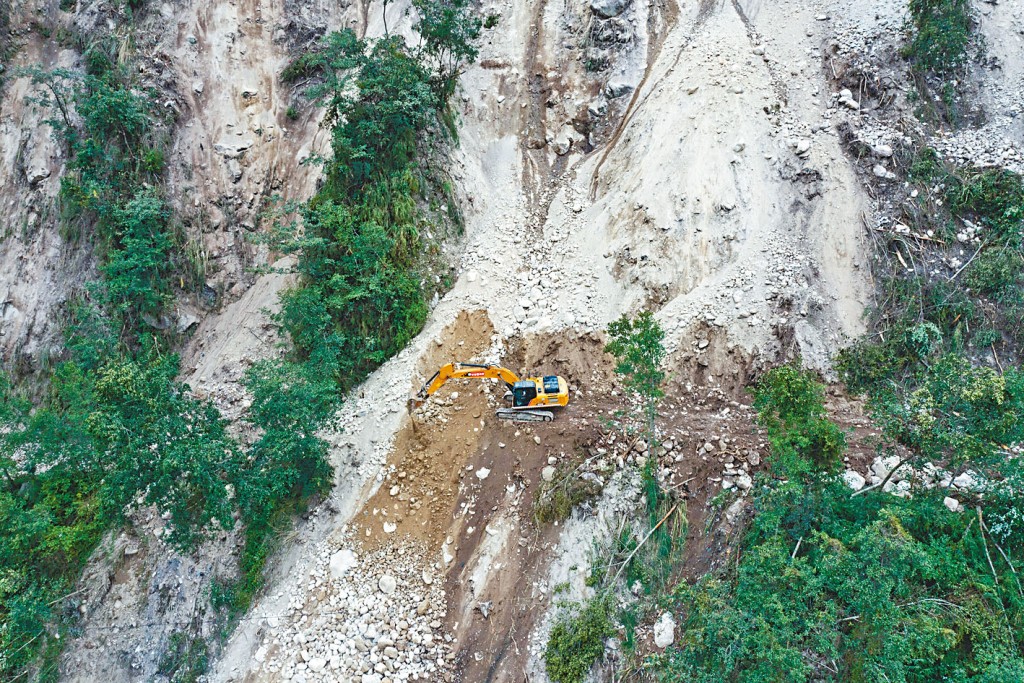 工人在地震災區搶修公路。　