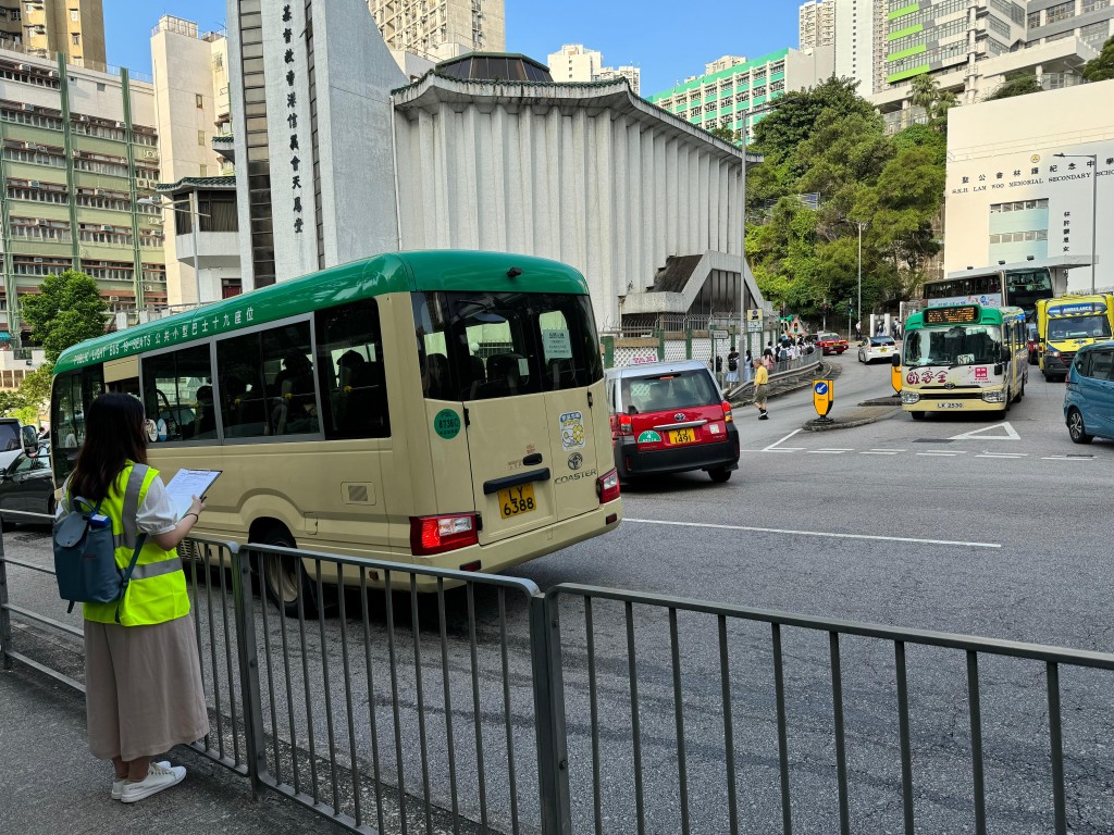 運輸署派出約110名人員，實地監察開學日港九新界主要公共運輸交匯處、鐵路站、學校區、口岸和隧道等交通情況，實時向緊急事故交通協調中心匯報。圖示人員（左）在葵涌葵盛圍學校區監察交通情況。（政府新聞處）