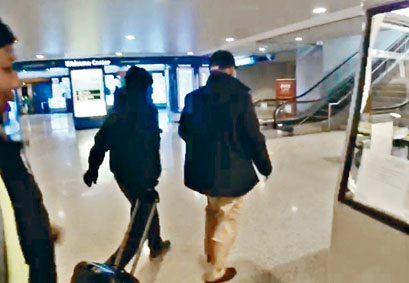 ■季炳雄(右)與一名替他拖篋的洋漢交談數句後,突急步前行。