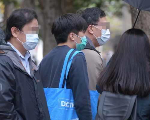 被告何志樂(持淺藍帆布袋者)。資料圖片
