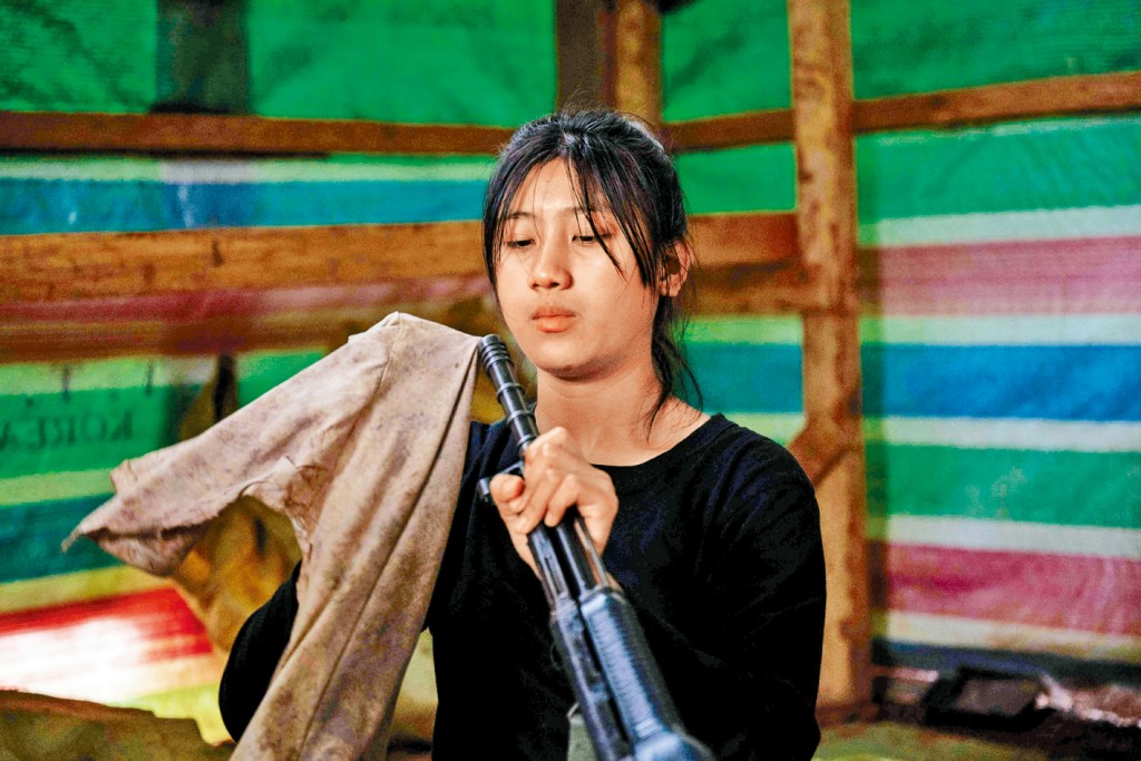 人民防衛軍(叛軍)一名女兵在緬北撣邦營地擦拭武器。