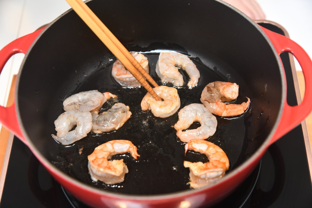 Step 4: 鑊內燒熱一湯匙油，大蝦煎至八成熟，盛起備用。 Heat 1 tbsp oil in a pan, fry the shrimps until medium well, remove and set aside.