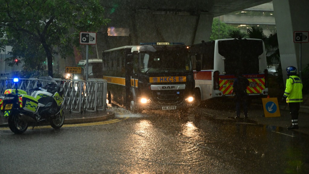 西九龙裁判法院外今早滂沱大雨下有轻微积水，接载黎智英的囚车要涉水而过。陈极彰摄