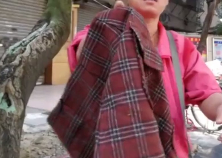 翌日女子拿着從回收箱得來的衣物在大街叫賣。（網上圖片）