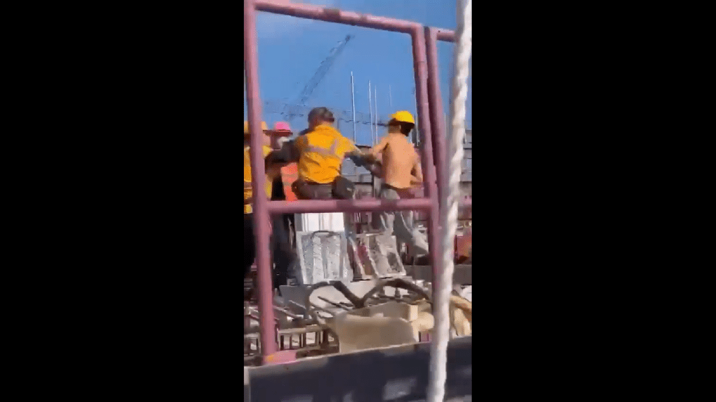影片看到1名工人被约几名工人按著，似乎处下风。