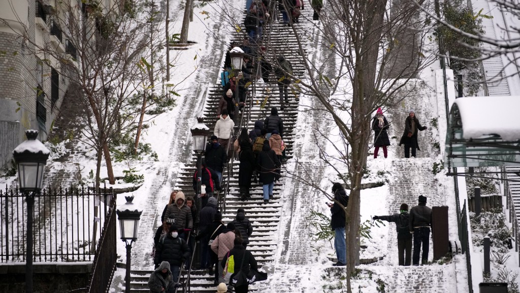 歐洲暴雪|巴黎蒙馬特區下雪後,人們走在階梯上。美聯社 歐洲暴雪|巴黎蒙馬特區下雪後,人們走在階梯上。美聯社