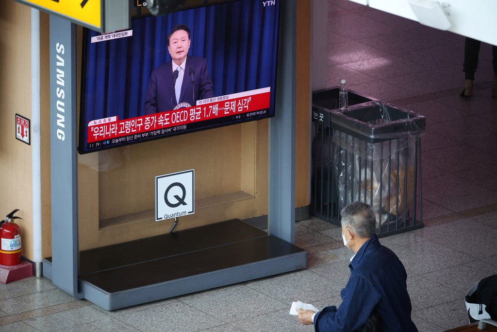 南韓民眾收看總統全國講話。路透社