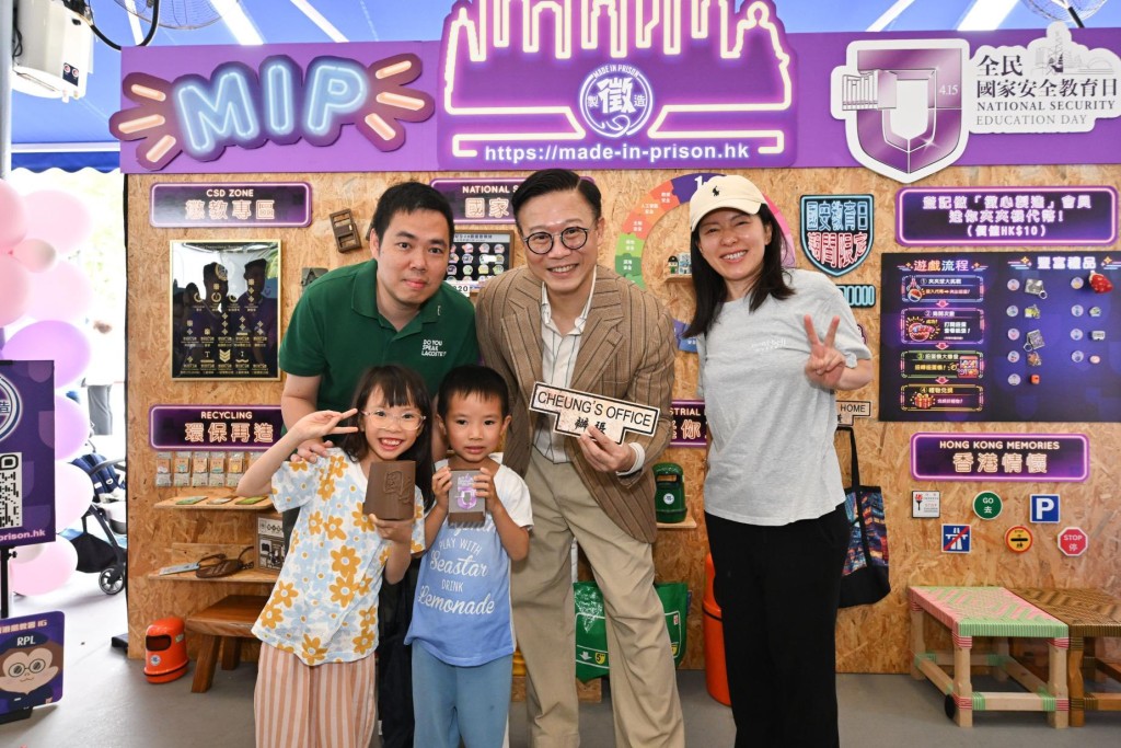 律政司副司長張國鈞（後排左二）及懲教署署長黃國興（後排右二）與選購「徵心製造」的「全民國家安全教育日」限定產品的市民合照。