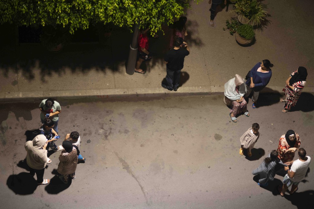 摩洛哥拉巴特发生地震后，人们避难并用手机查看新闻。AP