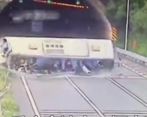 肇事旅遊巴失控後翻側在地，多名乘客從車窗中跌落馬路，再被車壓住。（網圖）