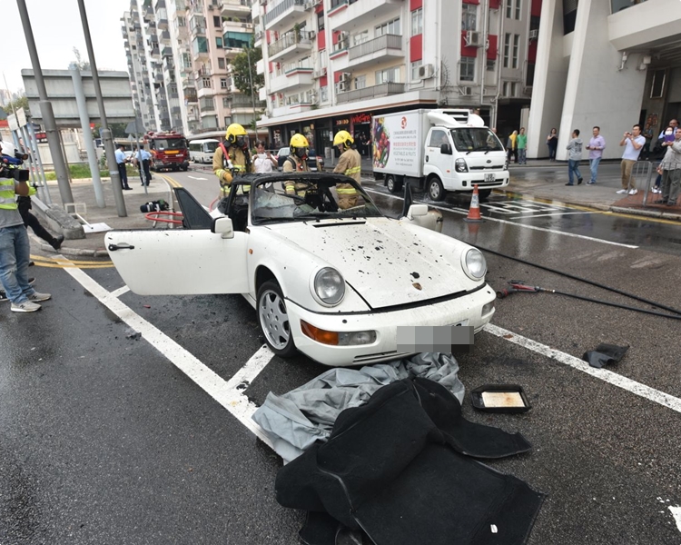 跑車停在路中,消防員將火救熄。楊偉亨攝