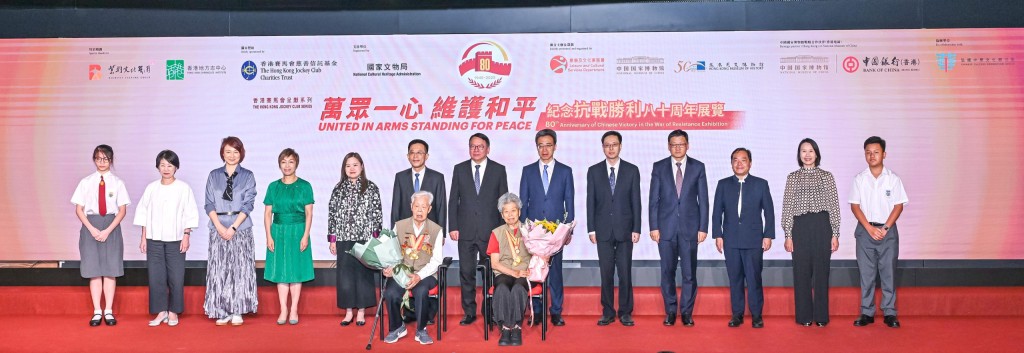 政務司司長陳國基（後排中）、中央人民政府駐香港特別行政區聯絡辦公室秘書長王松苗（後排左六）、國家文物局副局長孫德立（後排右六）、文化體育及旅遊局局長羅淑佩（後排左五）、中國國家博物館黨委書記楊帆（後排右五）、香港賽馬會董事龔楊恩慈（後排左四）等，與曾參加抗戰的老戰士（前排）在 「香港賽馬會呈獻系列：萬眾一心 維護和平─紀念抗戰勝利八十周年展覽」的開幕禮上合照。馬會供圖