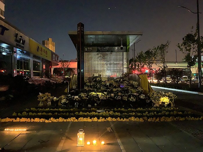民眾在鄭州市地鐵五號線沙口路站前獻上鮮花和擺放燭光。界面新聞