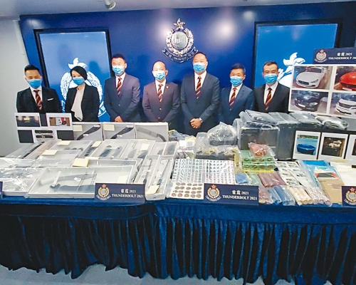 「O記」總警司黃維(中)與其他總區警官交代「雷霆2021」成果,並展示搜獲的大批武器及證物。