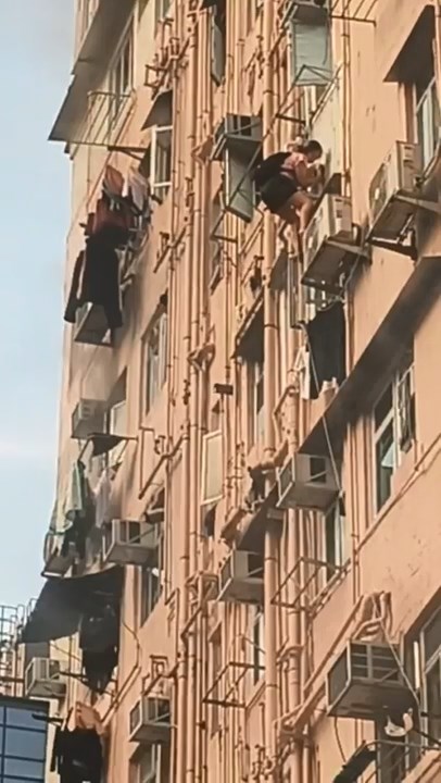 火警發生期間,有兩人爬出窗外並捉住外牆的水管,慢慢爬落下層單位逃生,非常驚險。讀者提供 火警發生期間,有兩人爬出窗外並捉住外牆的水管,慢慢爬落下層單位逃生,非常驚險。讀者提供