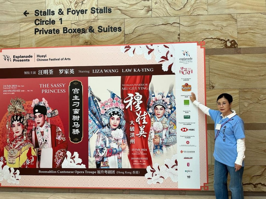 汪明荃在自己和罗家英主演的粤剧广告布景板打卡。