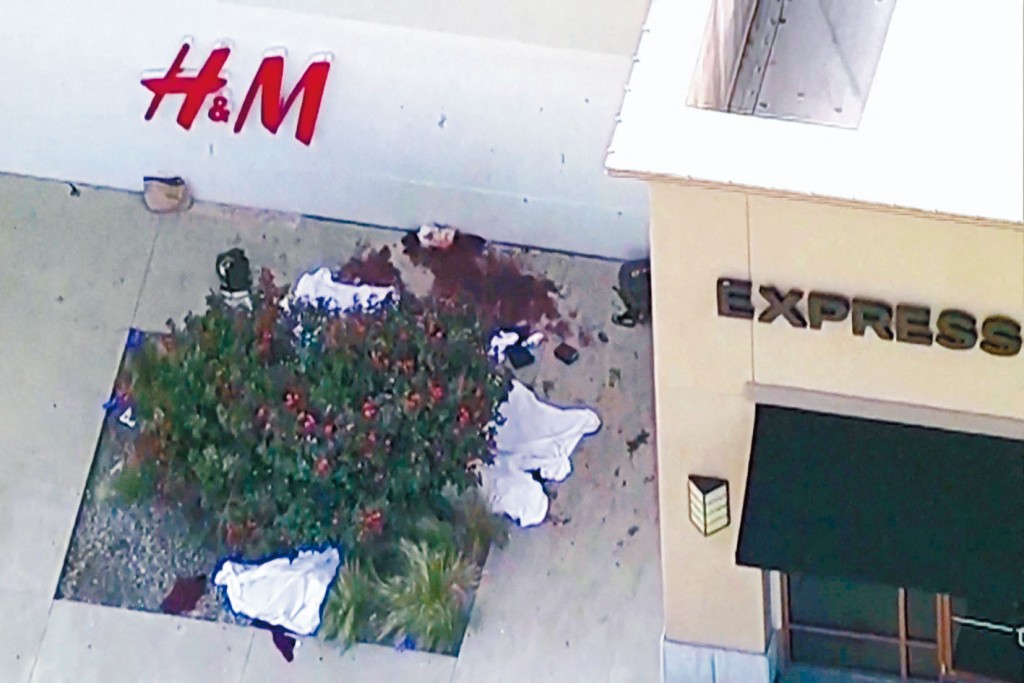 数具盖上白布的尸体躺在服装店外地上。