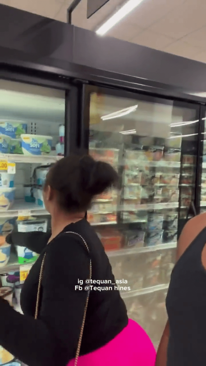女的打开超市的雪柜。
