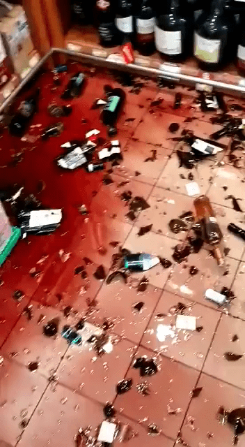 地震时有酒铺的酒瓶跌落地破碎，致一地都是红酒。网图