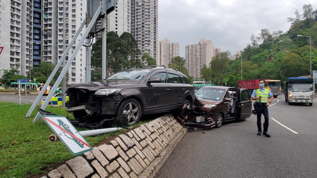 其中一輛私家車擱在路中心中央花槽的石壆上。林思明攝