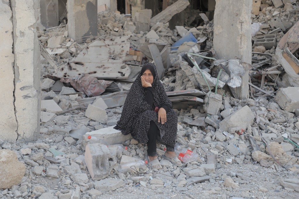 一名女居民坐在瓦礫上。新華社