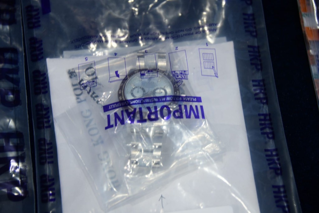 警方檢獲現金及提款卡等證物。楊偉亨攝
