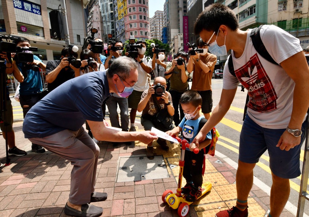 唐英年(左)向市民派發單張,宣傳人大政協選委政綱。