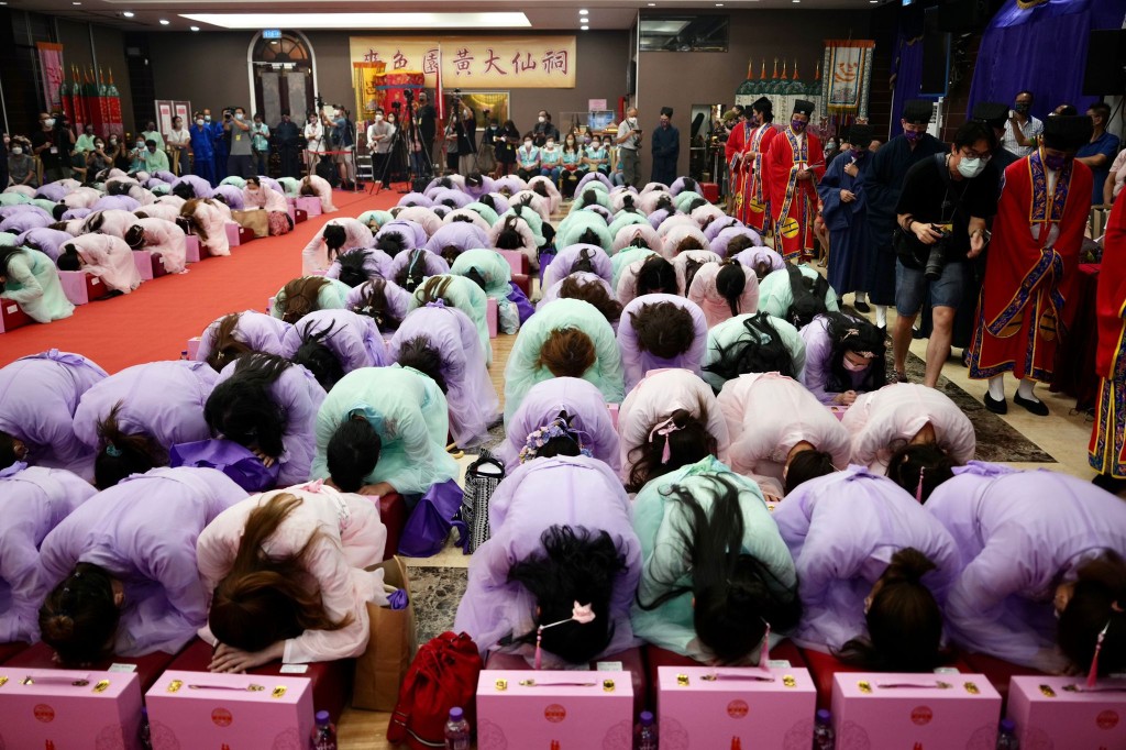 近200名穿着華服的女性向黃大仙像行三跪九叩禮。