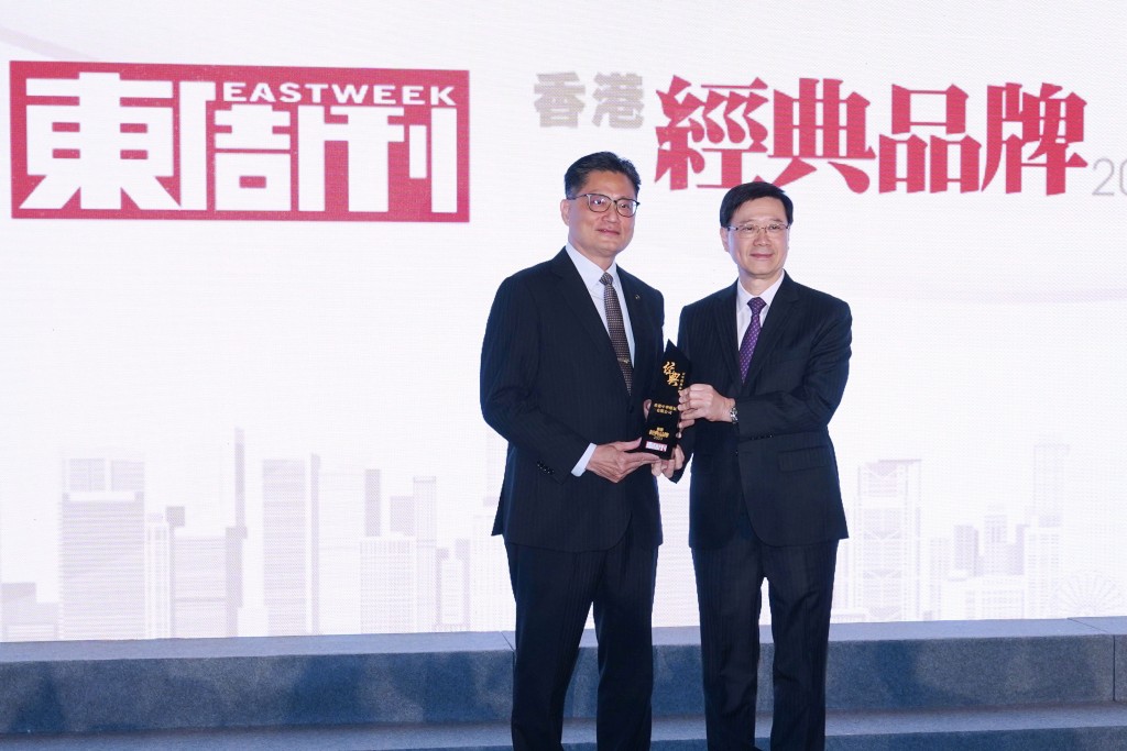 特首李家超（右）頒發「百年經典品牌」大獎給「香港中華煤氣」，並由中華煤氣企業事務總監楊松坤（左）代表領獎。