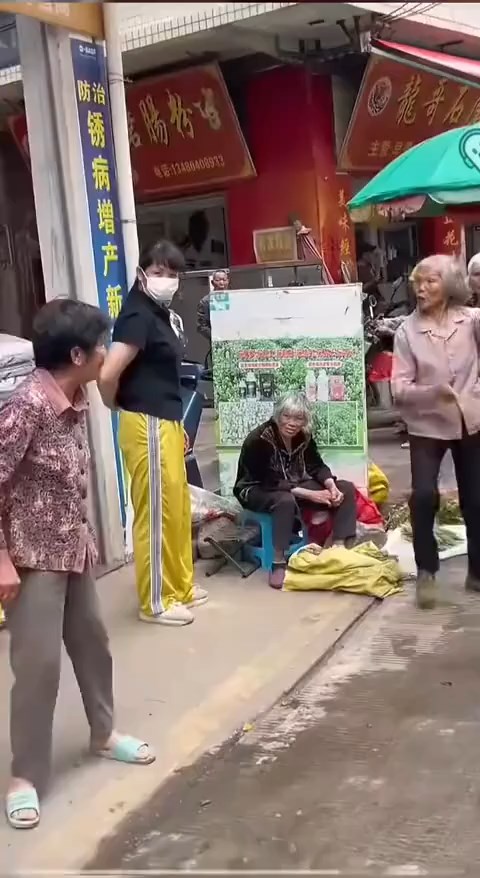 白发老妇与邻人起争执时，连续6次摆出“开枪”手势。抖音@月亮好物分享