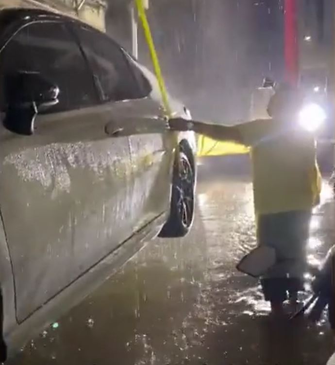 茂名有居民为免爱车被水淹坏，找「吊鸡车」将汽车吊上天台避水。影片截图