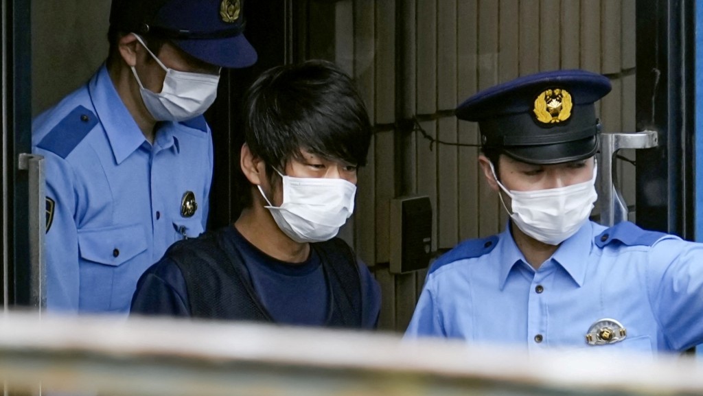 兩名警員將疑兇帶上警車。REUTERS