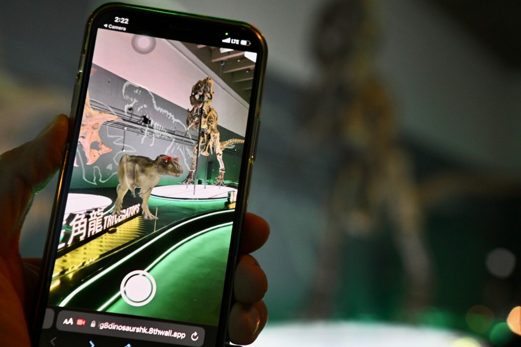 參觀者利用智能手機，以擴增實境技術與恐龍互動。政府新聞處圖片