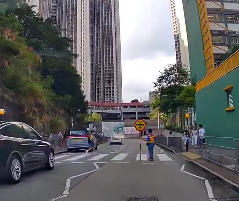 白色私家車直衝斑馬線，有途人為之側目。fb車cam L（香港群組）影片截圖