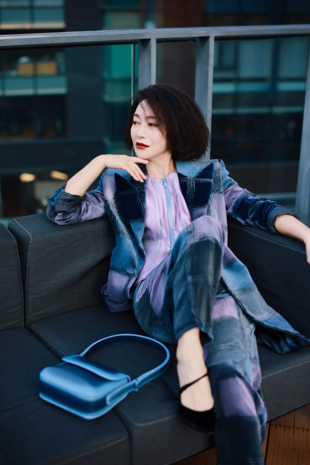 惠英红身穿Giorgio Armani 2021秋冬系列蓝色天鹅绒长身外套/$52,500及长裤/$24,500，配搭粉红色拉摙上衣/$22,500及La Prima手袋/$17,000，造型刚柔兼备。（Giorgio Armani）