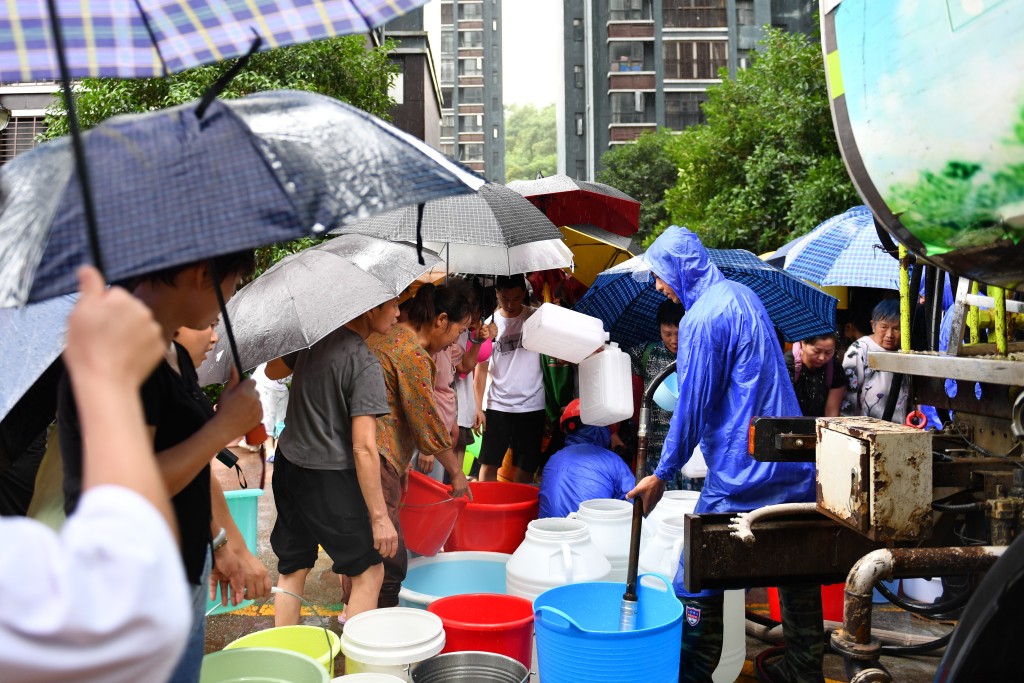 湖南連日暴雨已有40多萬人受災。圖為災民排隊取食水。新華社