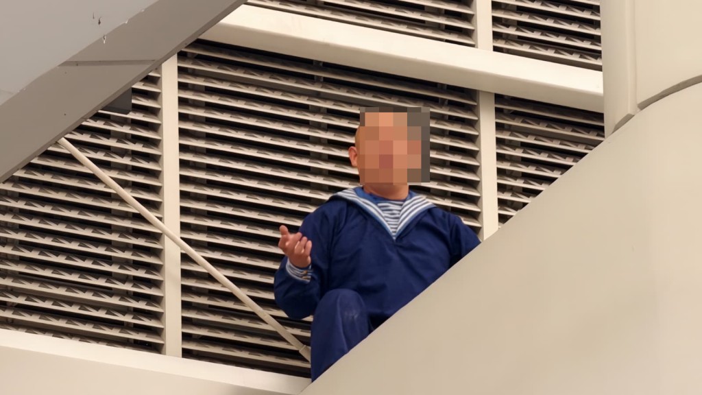 男子危坐在L7離境大堂天橋一位置,情緒激動。黃文威攝 男子危坐在L7離境大堂天橋一位置,情緒激動。黃文威攝