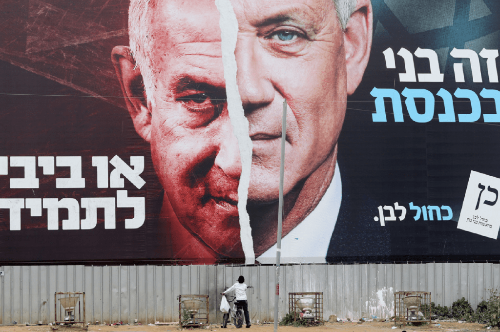 以色列現任總理尼坦雅胡（左）與前任國防部長甘茨（右）是政壇對手，二人現因以巴衝突而組緊急聯合政府。圖為2021年以色列國會大選時的街頭海報。路透社
