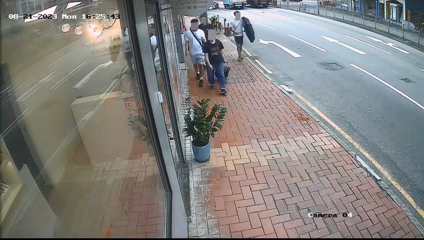 3名男子手持雨傘作遮掩，企圖打開前方女子的背囊盜竊。