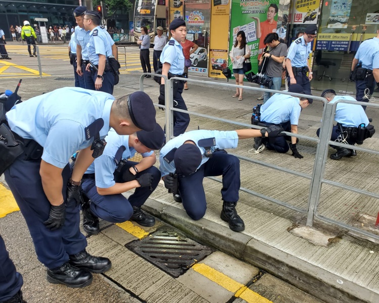 藍帽子警員揭起水蓋查看。梁國峰攝