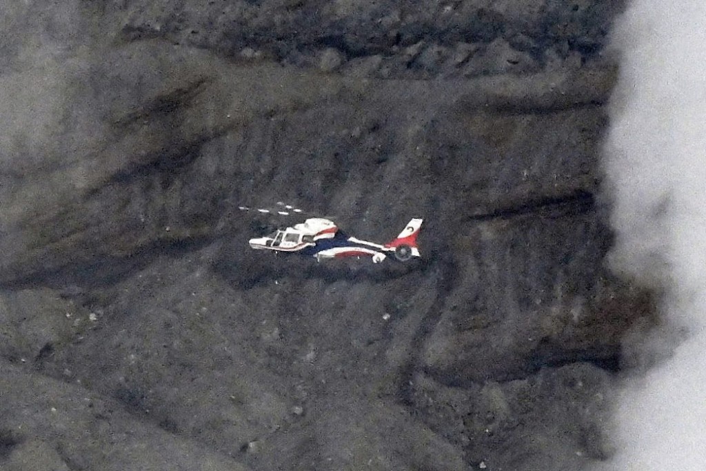阿蘇火山口附近一架觀光直升機失蹤，縣政府的防災直升機在現場上空搜尋。美聯社