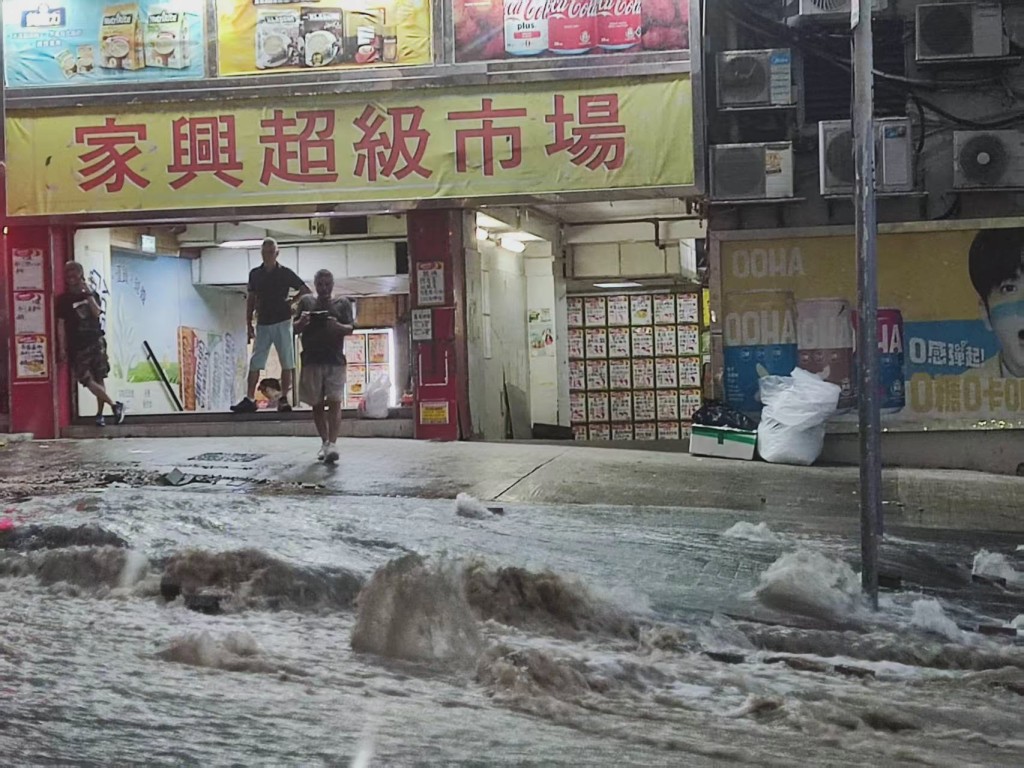 泥水衝破路磚，如瀑布沿斜路湧下。FB：龐智笙