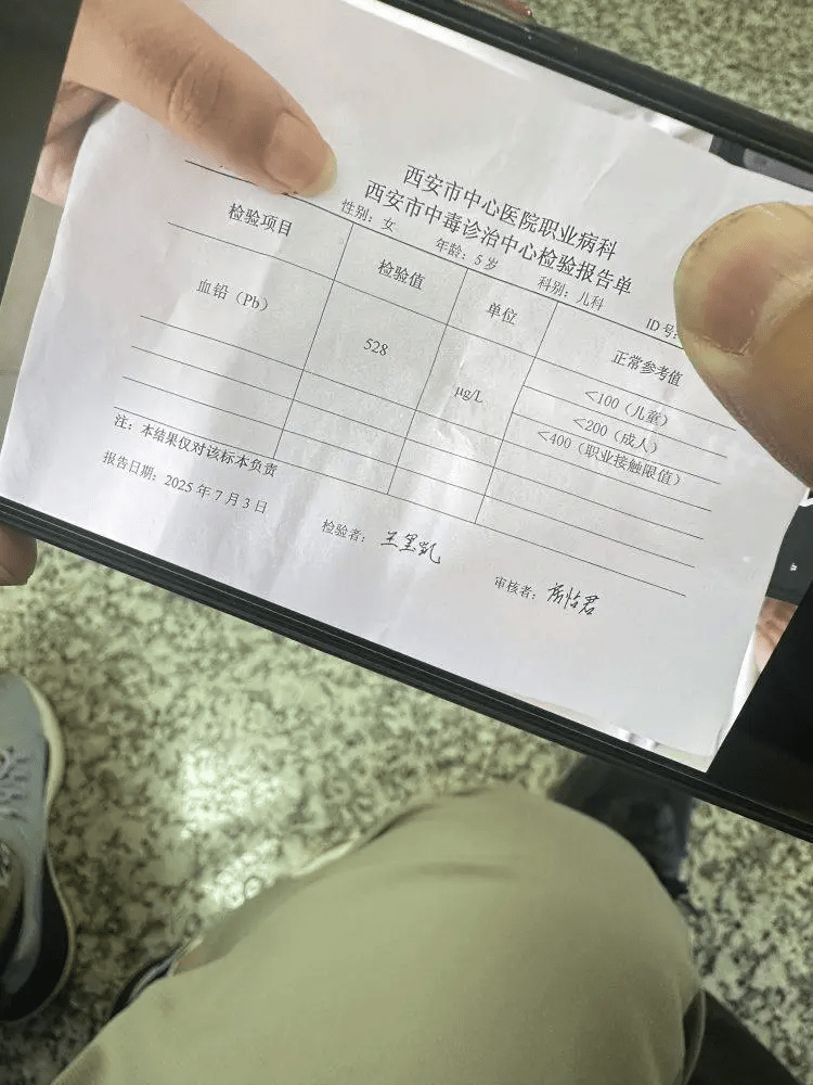 家长展示孩子检测血铅超标,为铅中毒。 家长展示孩子检测血铅超标,为铅中毒。